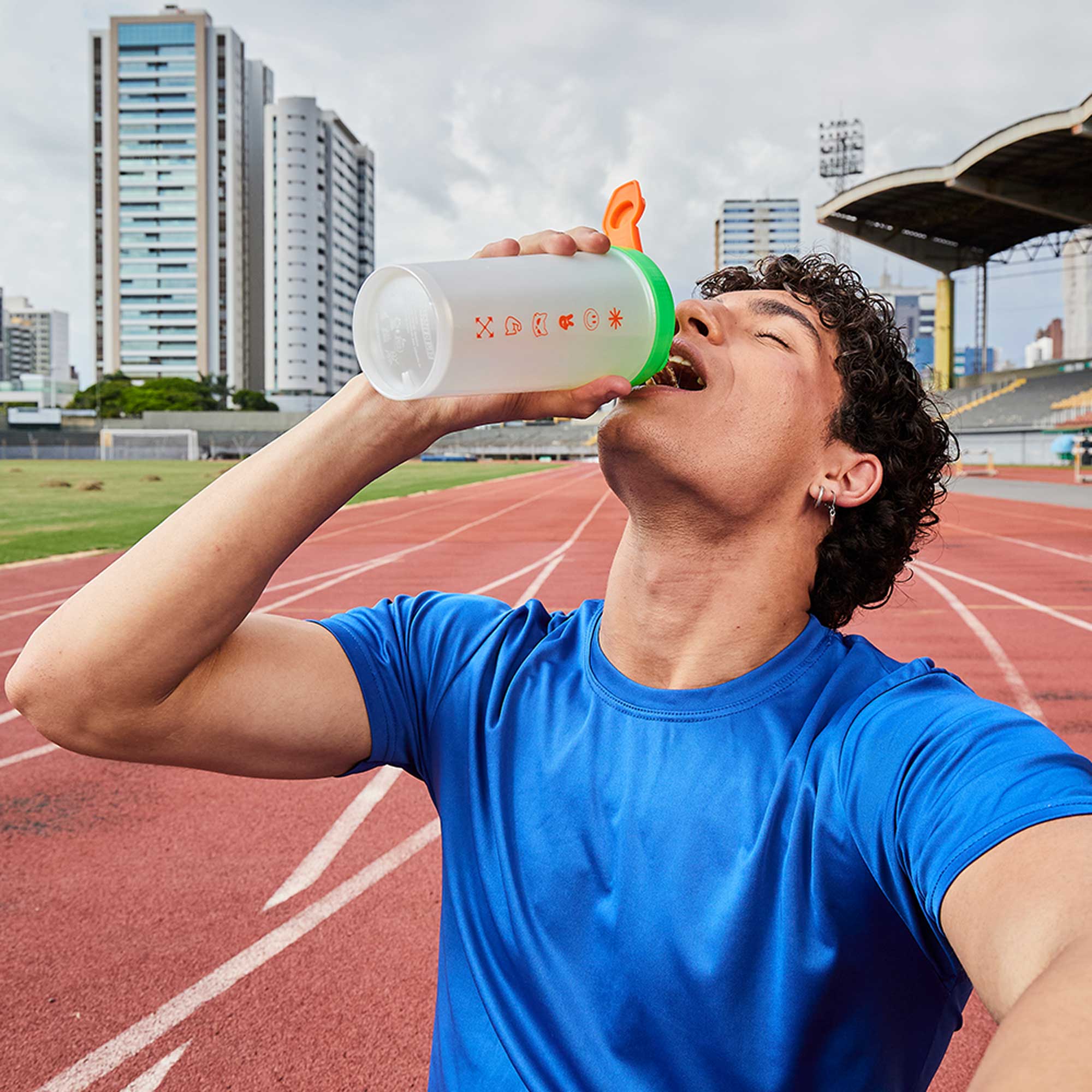 Coqueteleira SQUADZ MUSCLE Branco Pérola com Laranja 600ml — Homem bebendo