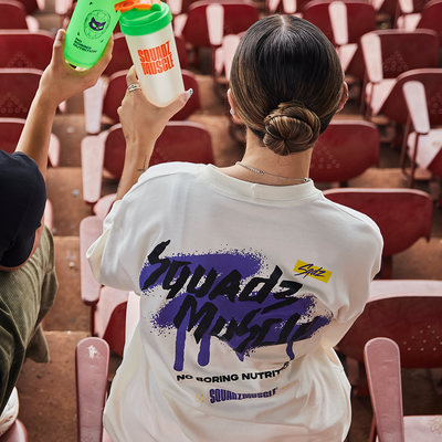 Camiseta Oversized Marfim com Roxo SQUADZ MUSCLE — Mulher de costas na arquibancada