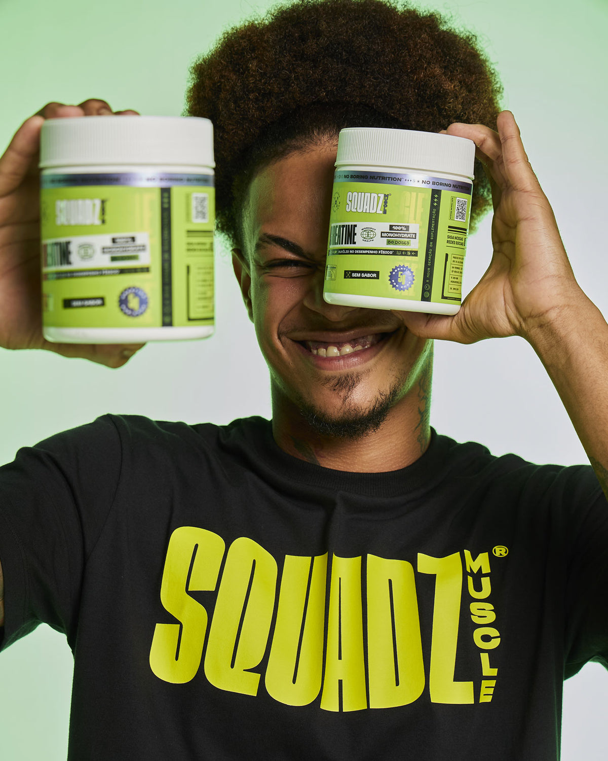 Homem com dois potes de Creatine cobrindo os olhos