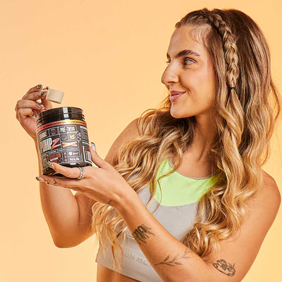 PUMP-Z Pré-Treino Tangerin Bomb 300g — Mulher com o pote