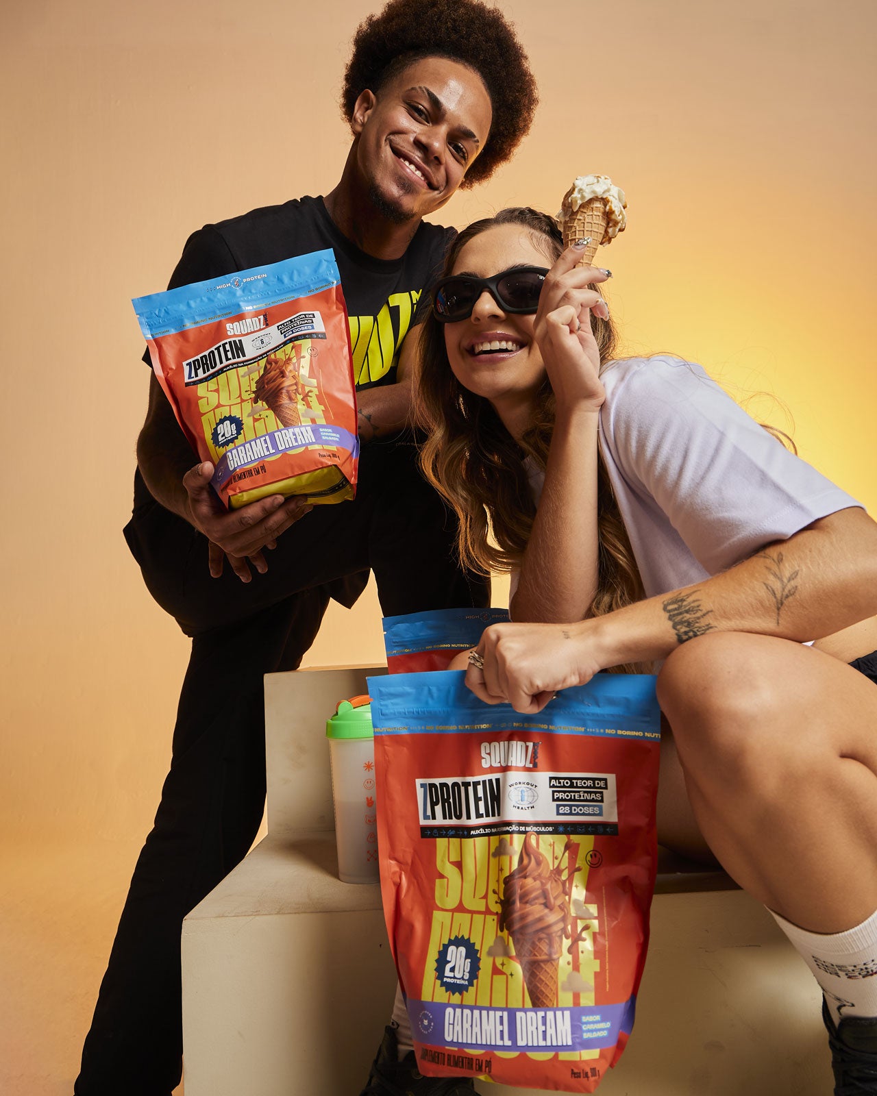 Duas mulheres agachadas segurando sacos de ZPROTEIN Caramelo Salgado